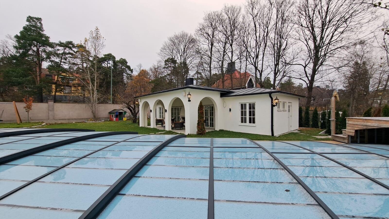 Färdigt poolhus med valvbågar och pool med skjutbart poolskydd
