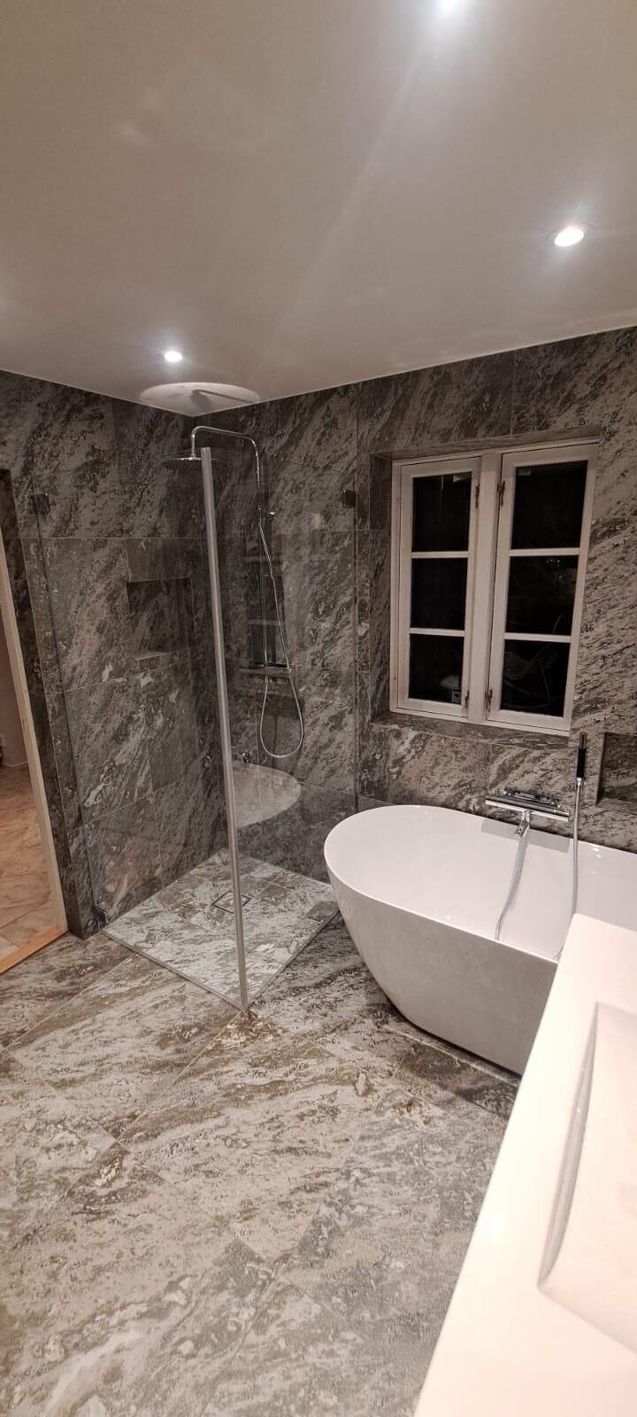 Badrum med marmorkakel, walk in-dusch och fristående badkar