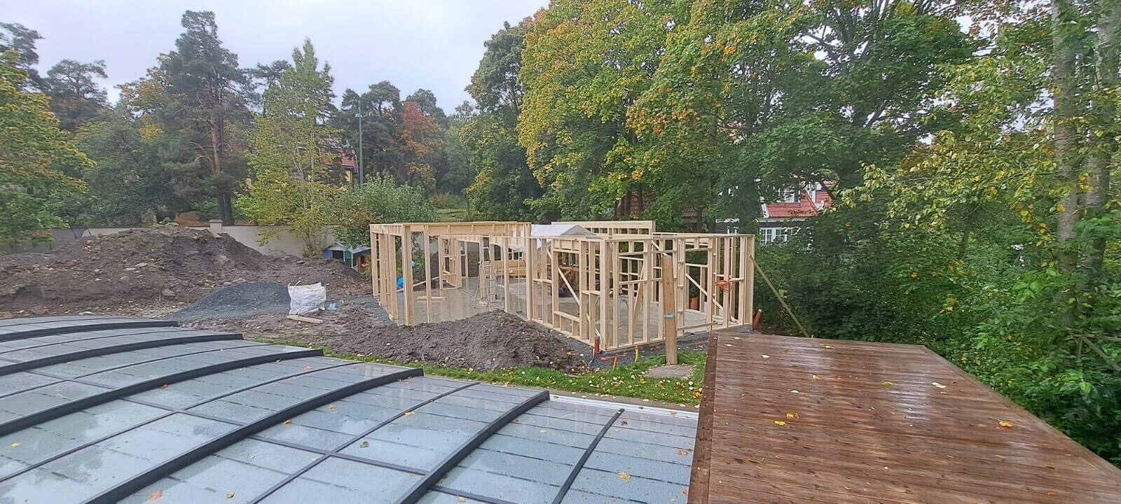 Poolhus under byggnation intill pool med poolskydd